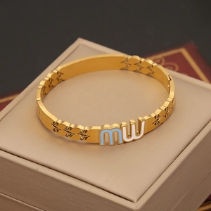 Detailed close-up of golden stainless steel bracelet featuring blue and white enamel mw charm
