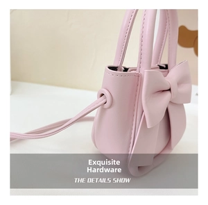 Detail view of pink PU leather mini bag featuring a large decorative bow and strap