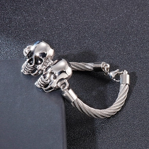 Bracelet homme avec double crâne en acier inoxydable poli et câble en acier
