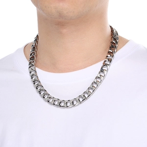 Close-up of a silver stainless steel Cuban link chain necklace worn by a male model