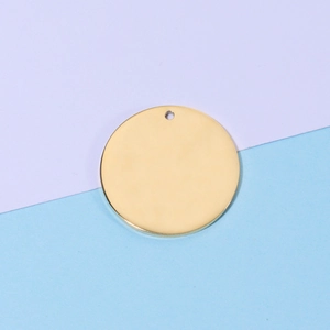 Macro view of blank round 18k gold-plated stainless steel pendant with hanging hole