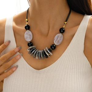 Close-up of a double-layered acrylic oval pendant necklace worn on a female model