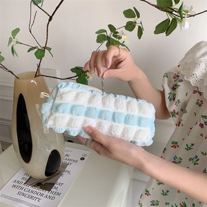 Detail of soft bubble texture on blue and white striped storage bag held by hand