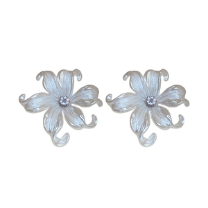 Elegant white acrylic flower stud earrings with shimmering pearl texture and crystal center