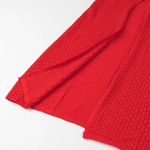 Macro détaillée du tissu en maille rouge avec texture alvéolée ajourée respirante