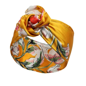 Detailansicht des ingwergelben Blumen-Samtstirnbands mit seidiger Textur und Knotendesign