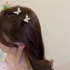 Detailed view of elegant butterfly hair claw with pearls and rhinestones in hair