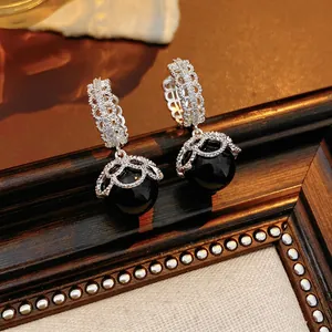 Vintage style gold-plated earrings with black pearl pendant and hollow silver flower design
