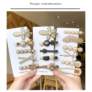 Detailed set of elegant pearl and rhinestone hair clips on a white presentation card