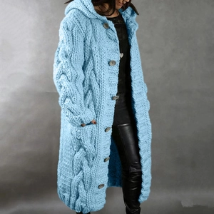 Macro detail of chunky cable knit texture and large buttons on long hooded cardigan