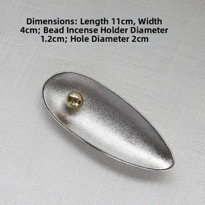 Silver leaf-shaped incense burner detail with dimensions 11cm by 4cm and gold ball