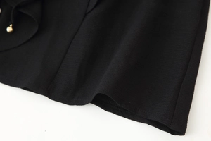 Macro shot of black chiffon ruffled hem featuring fine textured weave and metal bead detail