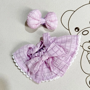 Close-up of pink checkered doll dress with white lace and matching bow hair accessory