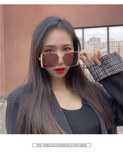 Close-up of women's oversized square sunglasses with pink frames and gold metal temples