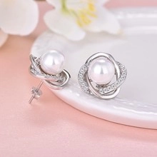 Detailed macro view of waterdrop metal circle earrings with white pearls and small zircons