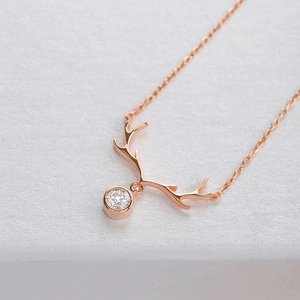 Close-up of rose gold reindeer antler necklace pendant with a sparkling cubic zirconia