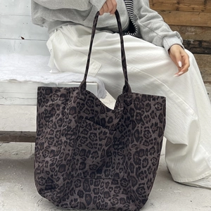 Detail of leopard print tote bag featuring a front square pocket and slim shoulder straps
