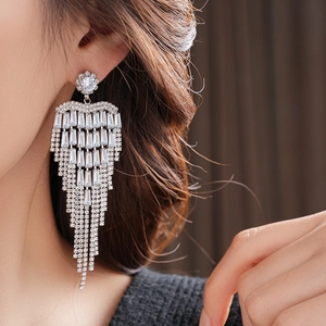 Close-up of model wearing long silver tassel earrings with sparkling cubic zirconia crystals