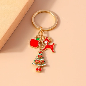 Detail shot of Christmas keychain with gold ring, red reindeer, apple, and tree charms