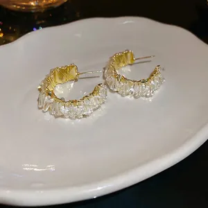 Vintage golden C-shaped hoop earrings with baguette crystal wrapping and metallic texture