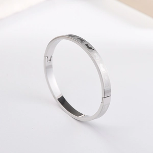 Macro detail of silver titanium steel bangle featuring creative etched footprints pattern