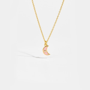 Detail of pink crescent moon pendant in gold necklace with clear zircon stone accent