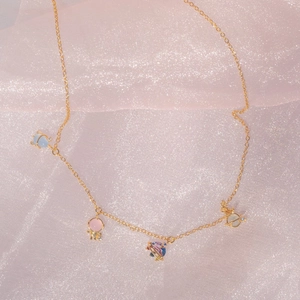 Space element necklace with colorful planet charms on a pink satin background