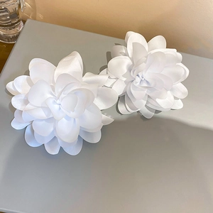 White layered fabric flower accessory detail close-up view showing exquisite texture.