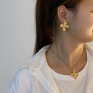 Fashion gold floral necklace and earrings set with pearl centers on a model