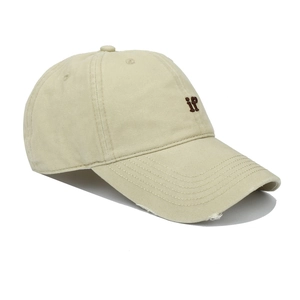 Close-up of beige baseball cap with frayed brim and brown if letter embroidery