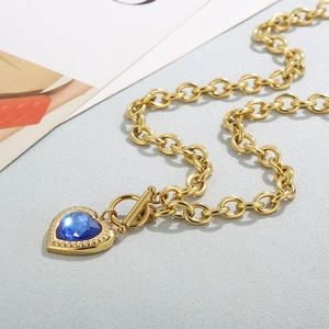 Detail showing the 18k gold heart pendant with blue crystal and toggle OT clasp