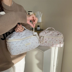 Detail showing quilted cotton cosmetic bags with cherry and bear patterns and top handles