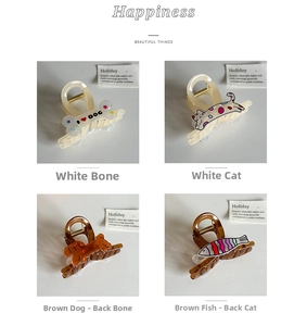 Collection of cat, dog, and fish shaped hair claws in cream and amber acetate