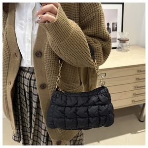 Détail du sac à bandoulière matelassé noir avec chaîne dorée et fermeture éclair