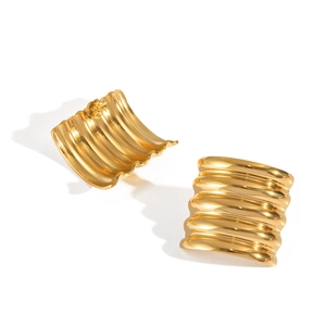 Detailed view of gold wavy earrings with horizontal stripes and polished metal texture