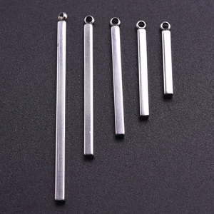 Close-up of five varied length silver 304 stainless steel bar pendants with polished finish