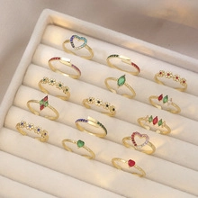Macro display of assorted gold-plated rings with colorful zircons in a jewelry box