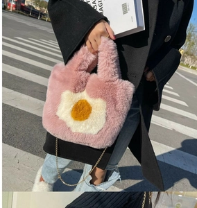 Close-up of pink plush tote bag with poached egg pattern and gold metal chain strap