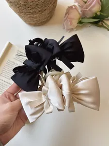 Detail of elegant black and cream silk bow hair claws in a French vintage setting
