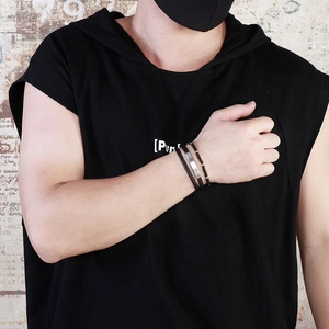 Detail shot of multi-layered men's braided leather bracelets with steel plate and beads