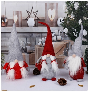 Close-up of plush Christmas gnomes with knit hats and long faux fur beards in cozy scene