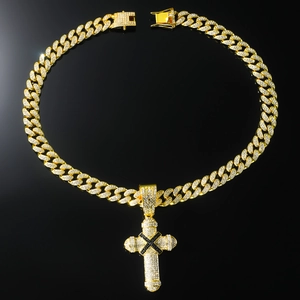 Macro detail of gold iced out cross pendant on cuban chain with black and clear stones