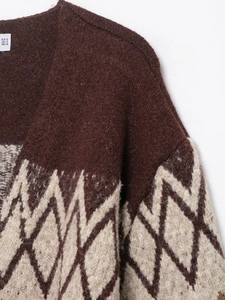Detail of brown knit cardigan featuring jacquard geometric patterns and size label