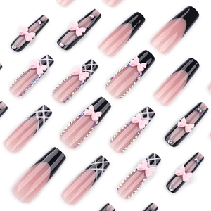 Extra long coffin press-on nails with black French tips, pink bows and sparkling rhinestones