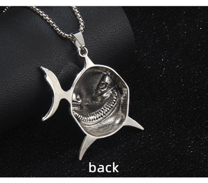 Macro view of the shark pendant back showing detailed embossed teeth and silver finish