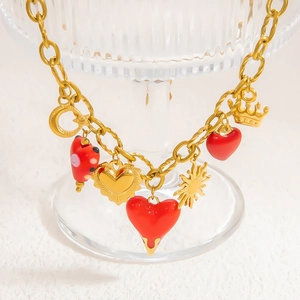 Collier en acier doré avec pendentifs cœurs rouges émaillés, lune et soleil
