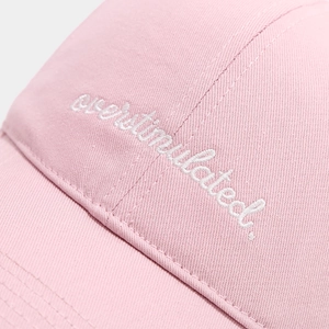 Detail of white overstimulated embroidery on soft pink cotton twill baseball cap