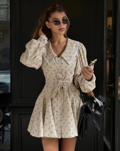 Détail de robe courte fleurie avec col Claudine en dentelle et manches bouffantes
