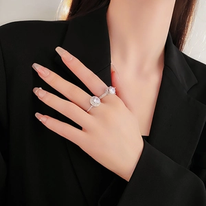 Close-up of stacked silver rings with zircon pavé and solitaire setting on model finger