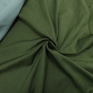 Détail de la texture du tissu vert olive et du drapé fluide pour robe d'été